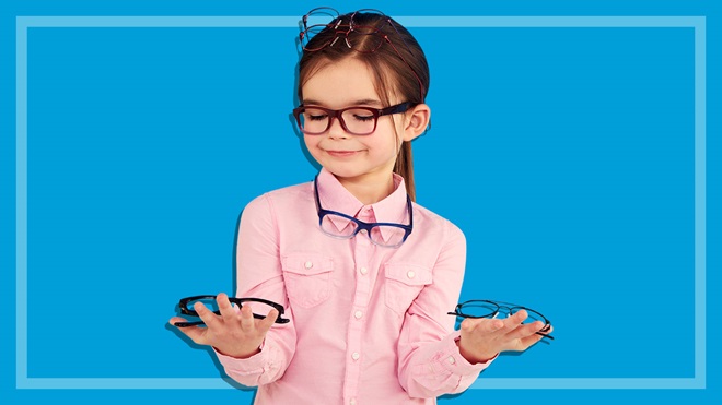 girl wearing prescription glasses holding more in her hands